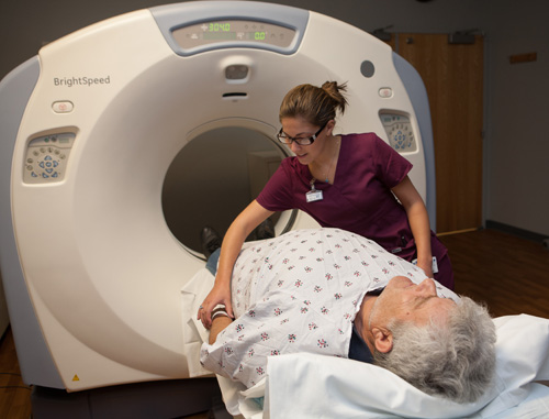 A technician assists a patient before an MRI